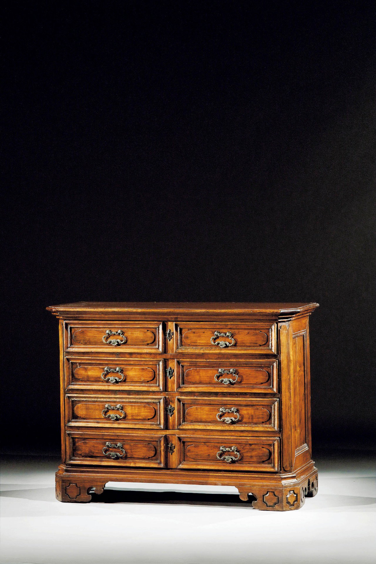 Kleine und seltene lombardische Nussbaumkommode mit 4 Schubladen, die mit einer eleganten Kartusche verziert sind, die sich an der Seite des Möbels wiederholt. Lombardei, frühes 17. Jahrhundert. Maße cm. 101 x 54 h. 90